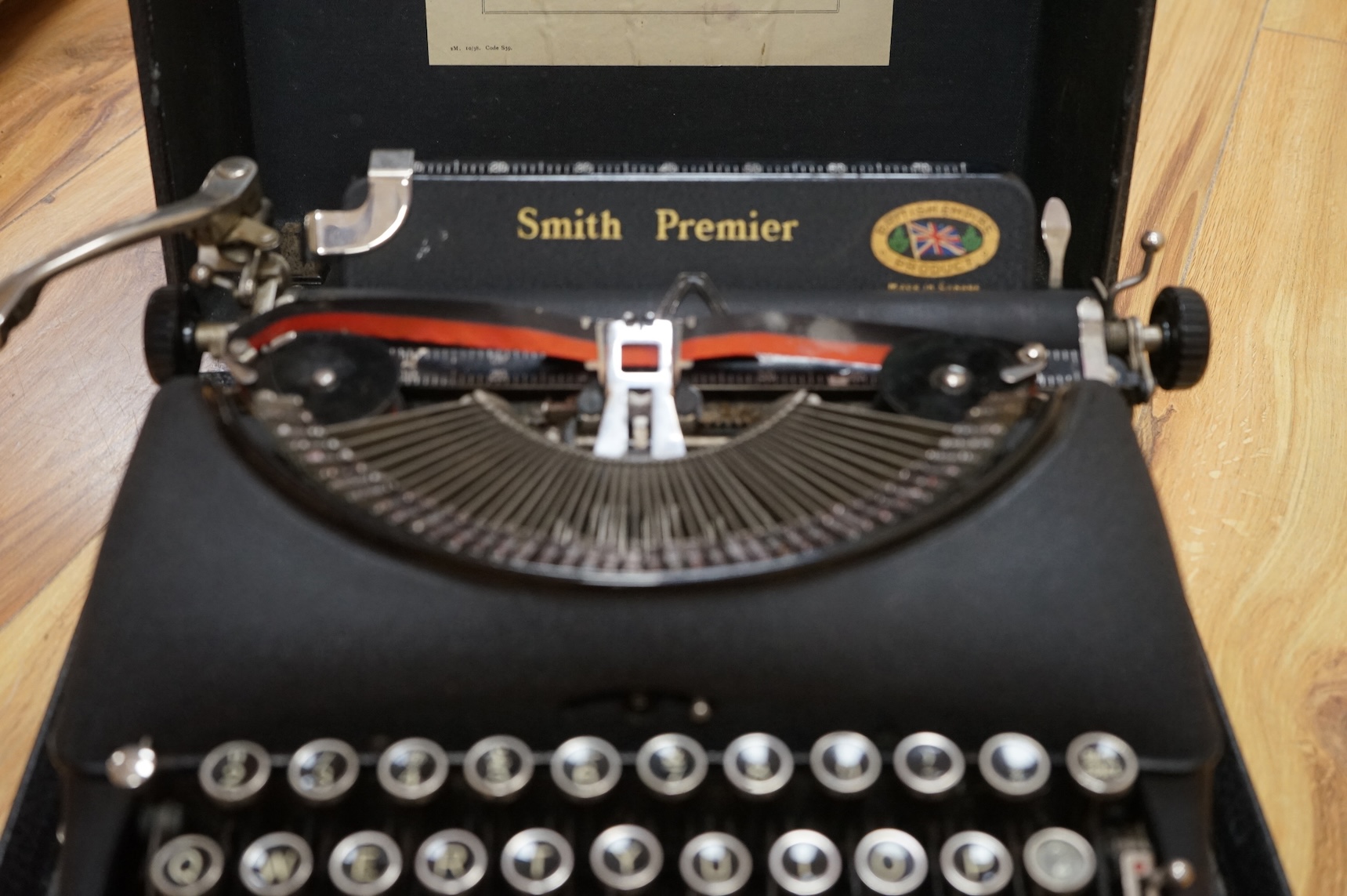 A cased portable Smith Premier Model 5 typewriter, with original guarantee sales label to the inside of the lid dated 22 January 1946.